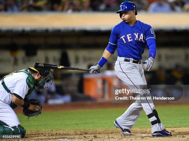 Catcher Geovany Soto of the Oakland Athletics gets hit in the head with the back swing of Leonys Martin of the Texas Rangers in the top of the third...