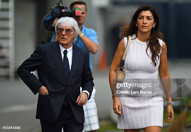 Supremo Bernie Ecclestone walks through the paddock with his wife Fabiana Flosi during previews ahead of the Singapore Formula One Grand Prix at...