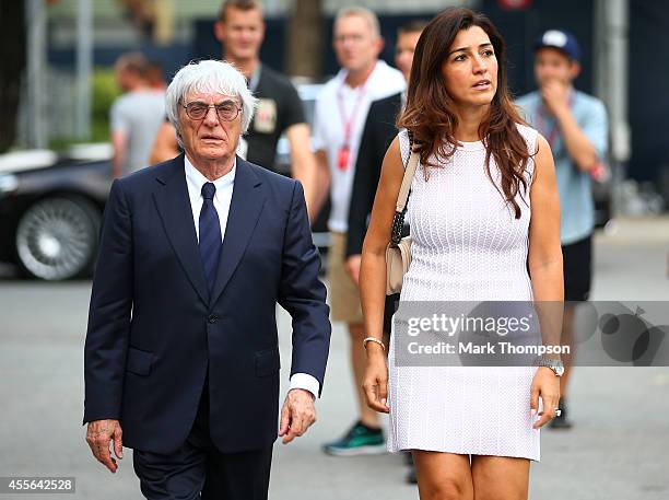 Supremo Bernie Ecclestone walks through the paddock with his wife Fabiana Flosi during previews ahead of the Singapore Formula One Grand Prix at...