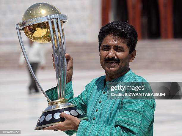 Former Pakistan cricketer Javed Miandad poses for a photograph with the ICC World Cup 2015 trophy during a ceremony at the mausoleum of the country's...