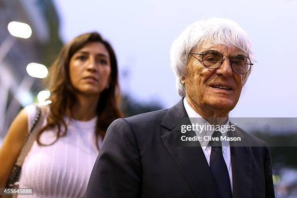 Supremo Bernie Ecclestone walks through the paddock with his wife Fabiana Flosi during previews ahead of the Singapore Formula One Grand Prix at...