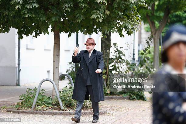 Samuel Finzi uses his smartphone upon his arrival for a photocall to promote the film 'Fritz Lang - Der andere in uns' on September 18, 2014 in...