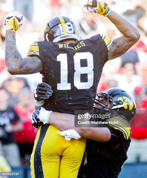 Wide receiver Derrick Willies celebrates with offensive lineman Austin Blythe of the Iowa Hawkeyes after scoring a touchdown in the fourth quarter...