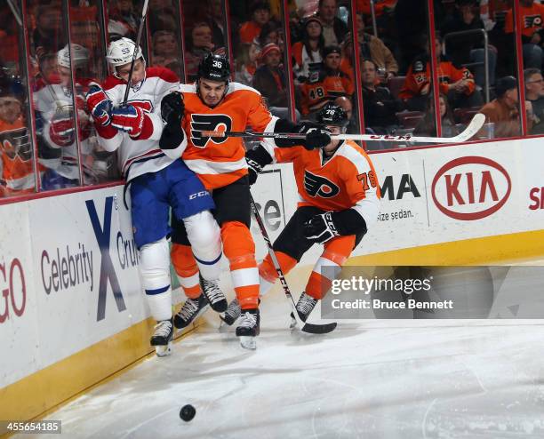 Ryan White of the Montreal Canadiens is hit into the boards by Zac Rinaldo of the Philadelphia Flyers during the second period at the Wells Fargo...