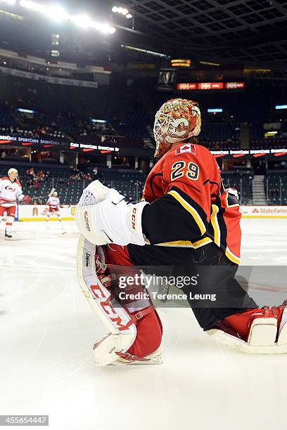 Reto Berra of the Calgary Flames stretches during the warmup against the Carolina Hurricanes at Scotiabank Saddledome on December 12, 2013 in...