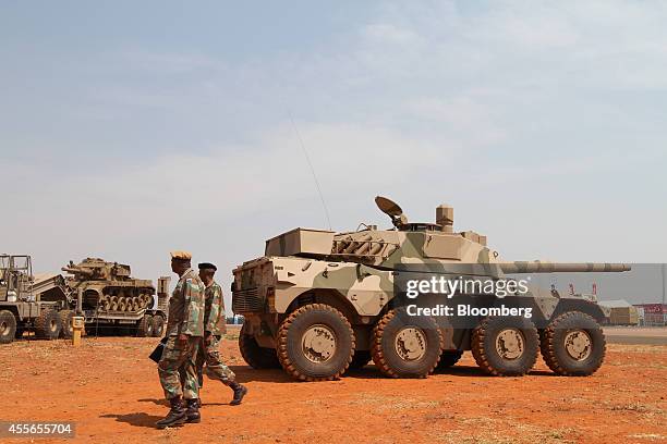 South African National Defence Force personnel walk past a Roikat and an Olifant main battle tank, left, manufactured by OMC Engineering Ltd., at the...