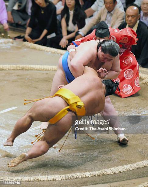 Ichinojo throws Shohozan to win during day four of the Grand Sumo Autumn Tournament at Ryogoku Kokugikan on September 17, 2014 in Tokyo, Japan.