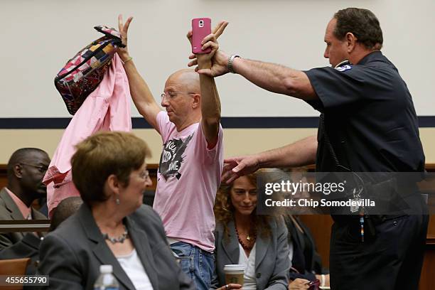 Demonstrator is removed from a House Armed Services Committee hearing after interrupting Defense Secretary Chuck Hagel as he testified about the U.S....