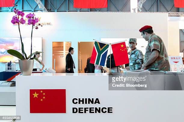 Mini South African, left, and Chinese national flags stand on a reception desk at the China Defence trade stand during the Africa Aerospace & Defence...