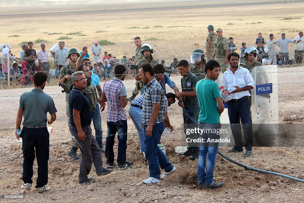 Syrians fleeing the war in their country wait to cross into Turkey