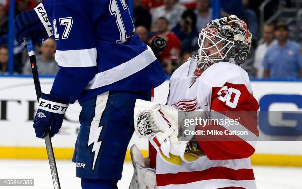 Goalie Jonas Gustavsson of the Detroit Red Wings takes a puck off the face mask behind Alex Killorn of the Tampa Bay Lightning at the Tampa Bay Times...