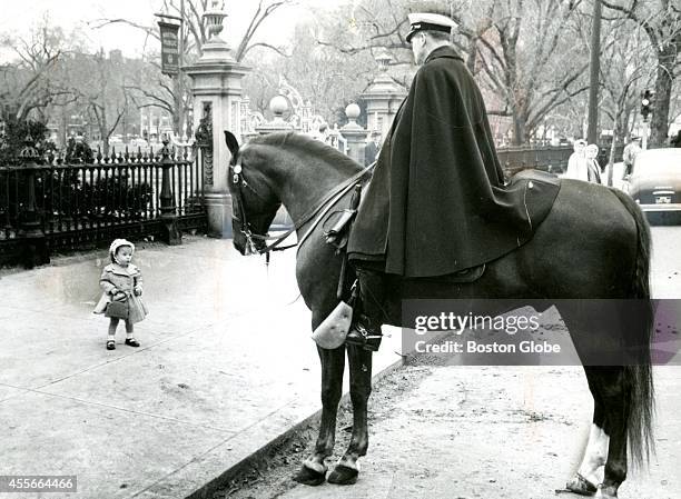 Little Elaine Martin, in her Easter finery, stopped to look at Officer Benjamin Donahue aboard his horse, Justin's Son, near the Boston Public Garden.