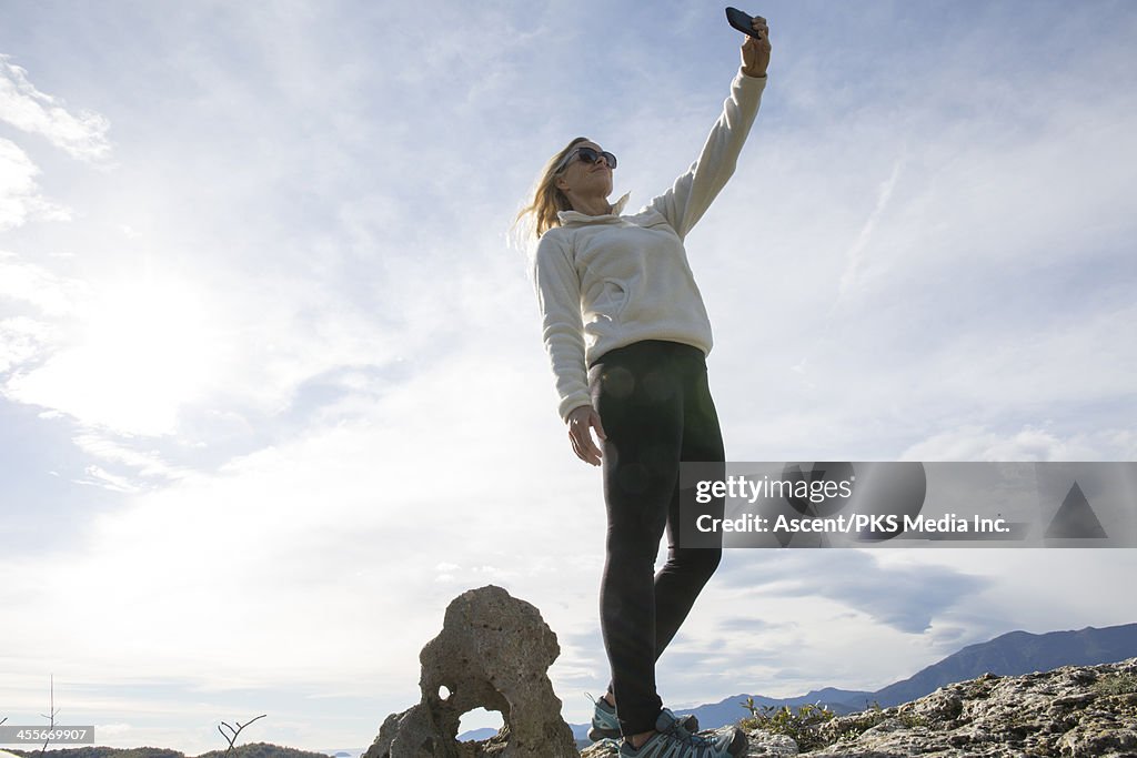 Woman takes "selfie" on ridgecrest, above hills