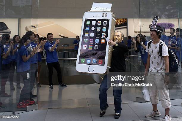 Customer wearing a Steve Jobs mask celebrates after purchasing a new iPhone at the launch of the new Apple iPhone 6 and iphone 6 plus at the Apple...