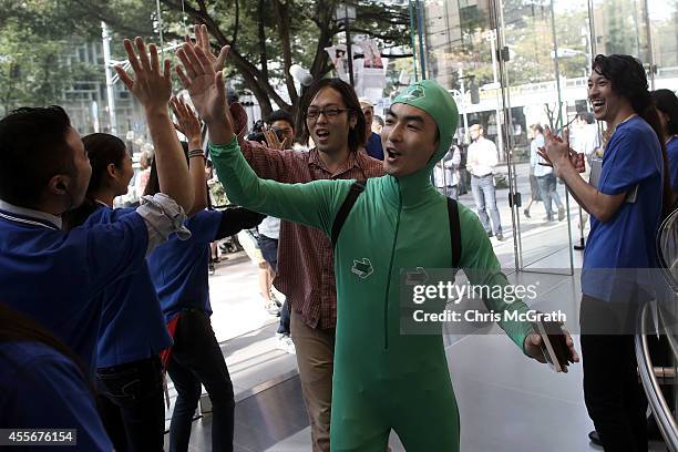 Apple store staff high five customers as they enter the store to purchase the new iPhones at the launch of the new Apple iPhone 6 and iPhone 6 plus...