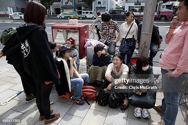 People wait in line to purchase a new iPhone at the launch of the new Apple iPhone 6 and iPhone 6 plus at the Apple Omotesando store on September 19,...