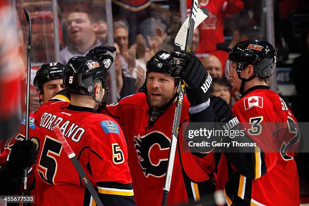 Brian McGrattan and teammates of the Calgary Flames celebrate a goal against the Carolina Hurricanes at Scotiabank Saddledome on December 12, 2013 in...