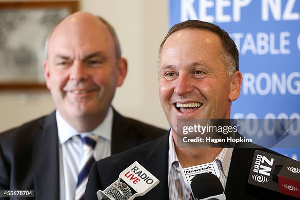 Prime Minister John Key enjoys a laugh while speaking to media as Minister for Economic Development Steven Joyce looks on during the National Party...