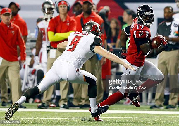 Wide receiver Devin Hester of the Atlanta Falcons avoids a tackle by punter Michael Koenen of the Tampa Bay Buccaneers on his way to returning a punt...