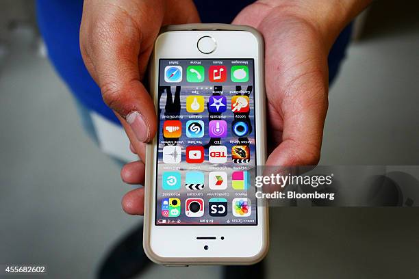 An Apple Inc. Employee holds an iPhone 6 for a photograph during the sales launch of the iPhone 6 and iPhone 6 Plus at the company's George Street...