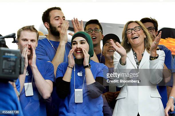 Angela Ahrendts, senior vice president of retail and online stores at Apple Inc., right, and employees cheer before opening the doors to the...