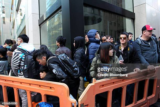 Customers wait in line outside the Apple Inc. George Street store during the sales launch of the iPhone 6 and iPhone 6 Plus in Sydney, Australia, on...