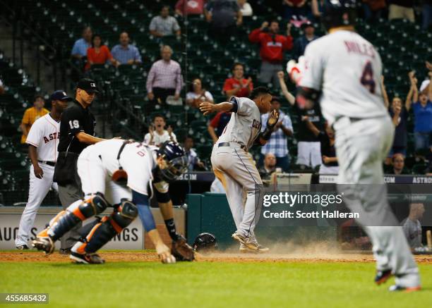 Jose Ramirez of the Cleveland Indians scores a run past Jason Castro of the Houston Astros in the 13th inning during their game at Minute Maid Park...