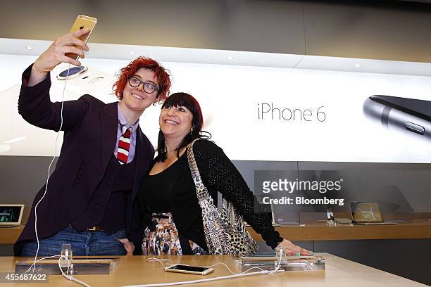 Customers Alice Clarke, left, and Katie Cincotta take a "selfie" photograph using an iPhone 6 Plus at the Apple Inc. George Street store during the...