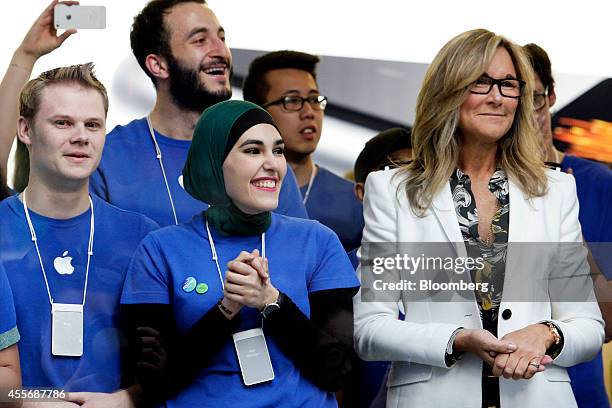 Angela Ahrendts, senior vice president of retail and online stores at Apple Inc., right, and employees look on before opening the doors to the...