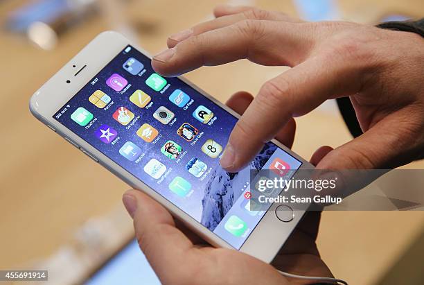 Shopper ltries out the new Apple iPhone 6 at the Apple Store on the first day of sales of the new phone in Germany on September 19, 2014 in Berlin,...