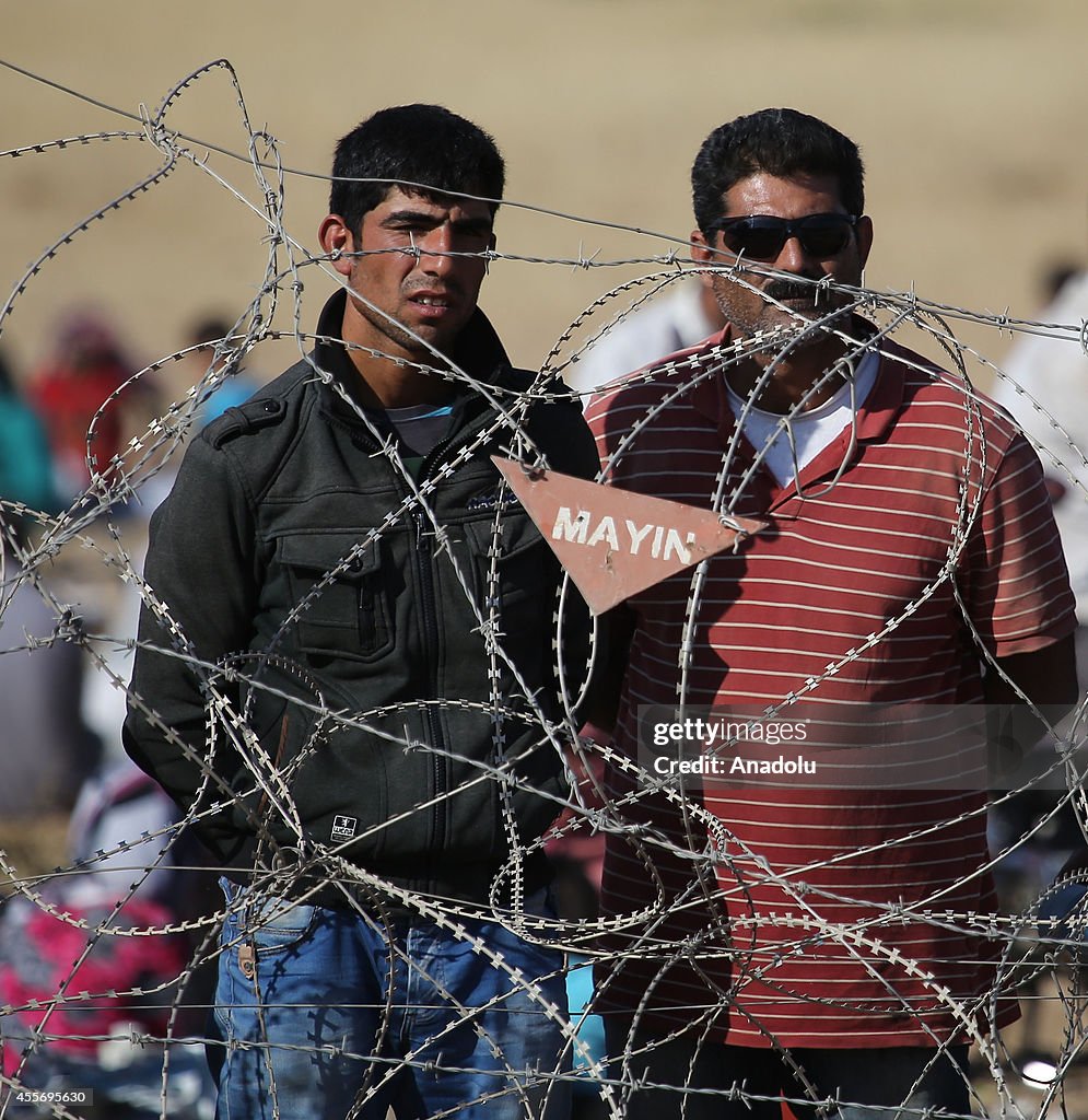 Syrians fleeing the war in their country wait to cross into Turkey