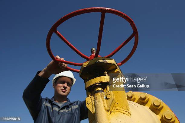 Worker, at the request of the photographer, grasps a hand wheel on a valve at the Dashava natural gas facility on September 18, 2014 in Dashava,...