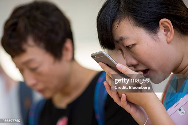 Customer tries the Siri voice recognition function on an Apple Inc. IPhone 6 Plus at the company's Causeway Bay store during the sales launch of the...