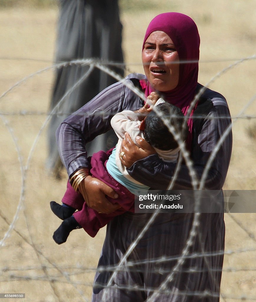 Syrians fleeing the war in their country wait to cross into Turkey