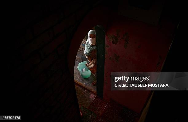 Kashmiri woman clears mud from her flood-damaged house in central Srinagar on September 19, 2014. The main city in Indian Kashmir has "drowned...