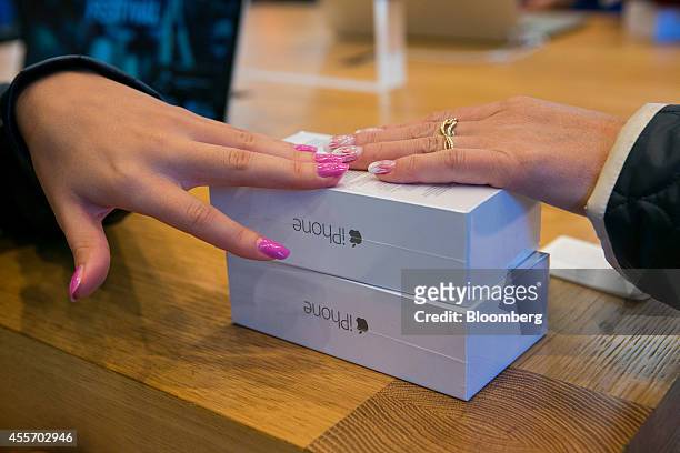 Female customers from Russia touch packaged iPhones during the sales launch of the iPhone 6 and iPhone 6 Plus smartphones at the Apple Inc. Store in...
