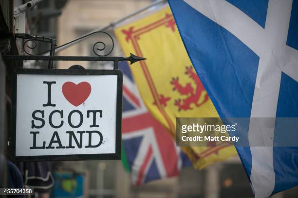 The Saltire flag flies next to the Royal Standard of Scotland and the Union Flag above a gift shop in central Edinburgh on September 19, 2014 in...