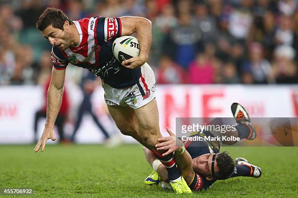 Anthony Minichiello of the Roosters is tackled by Ethan Lowe of the Cowboys during the 1st NRL Semi Final match between the Sydney Roosters and the...
