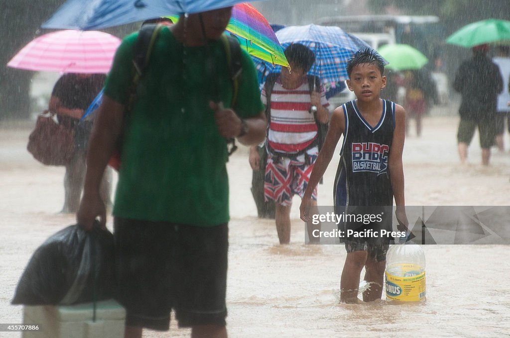 A boy along with residents wade in the streets of Provident...