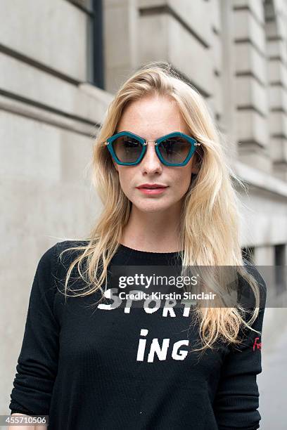 Model Poppy Delevingne is wearing Miu Miu sunglasses and a Bella Freud top on day 3 of London Collections: Women on September 14, 2014 in London,...