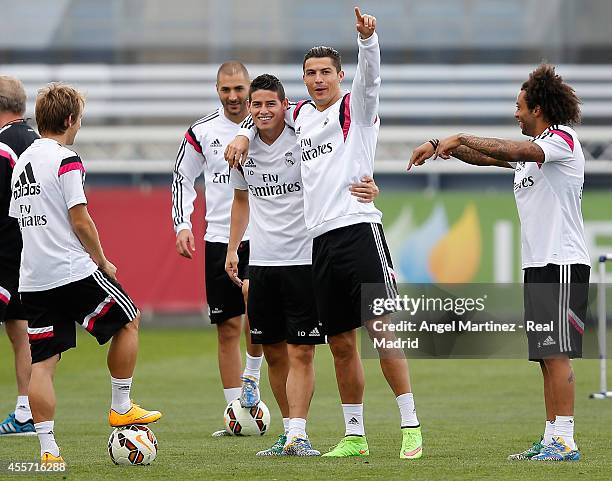 Cristiano Ronaldo of Real Madrid jokes with James Rodriguez during a training session at Valdebebas training ground on September 19, 2014 in Madrid,...