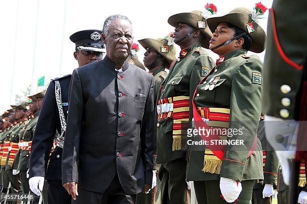 Zambia's President Michael Sata ) reviews a guard of honour outside the National Assembly building before officially opening the Zambian Parliament...