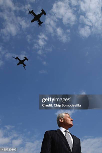 Secretary of Defense Chuck Hagel watches a flyover of Marine MV-22 Osprey aircraft during the Defense Department's National POW/MIA Recognition Day...