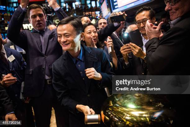 Founder and Executive Chairman of Alibaba Group Jack Ma rings a bell to celebrate as the Alibaba stock goes live during the company's initial price...
