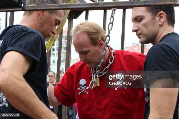 Canadian escape artist Dean Gunnarson performs cage escape over a lake on September 19, 2014 in Zhangjiajie, China.