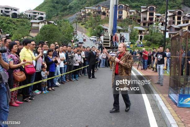 Canadian escape artist Dean Gunnarson performs cage escape over a lake on September 19, 2014 in Zhangjiajie, China.