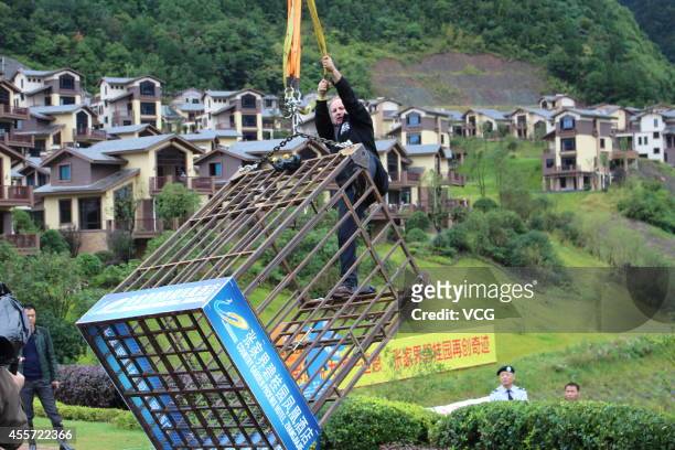 Canadian escape artist Dean Gunnarson performs cage escape over a lake on September 19, 2014 in Zhangjiajie, China.