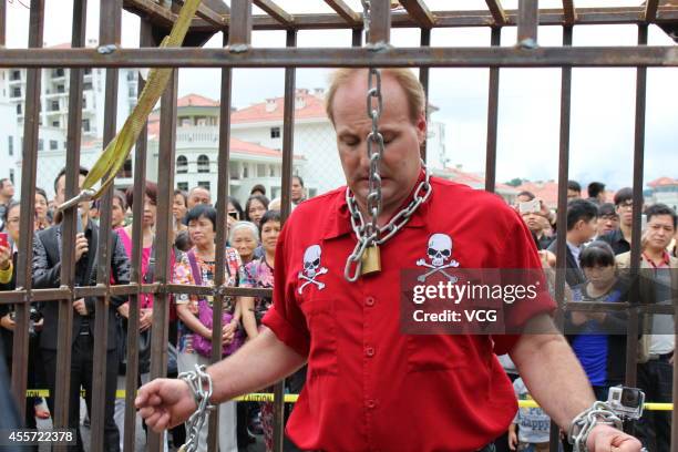 Canadian escape artist Dean Gunnarson performs cage escape over a lake on September 19, 2014 in Zhangjiajie, China.