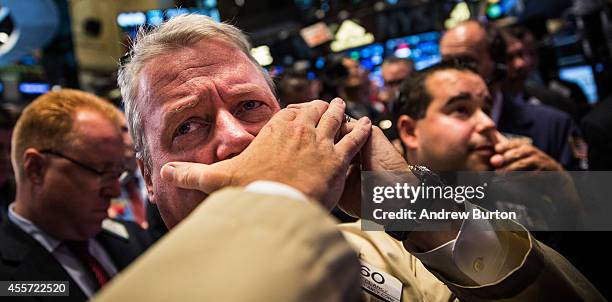 Traders work on the floor of the New York Stock Exchange while the price of Alibaba Group's initial price offering is decided on September 19, 2014...