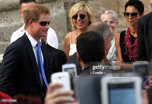 Britain's Prince Harry leaves at the end of the marriage of his friends, Charlie Gilkes and Anneke von Trotha Taylor, on September 19, 2014 at the...